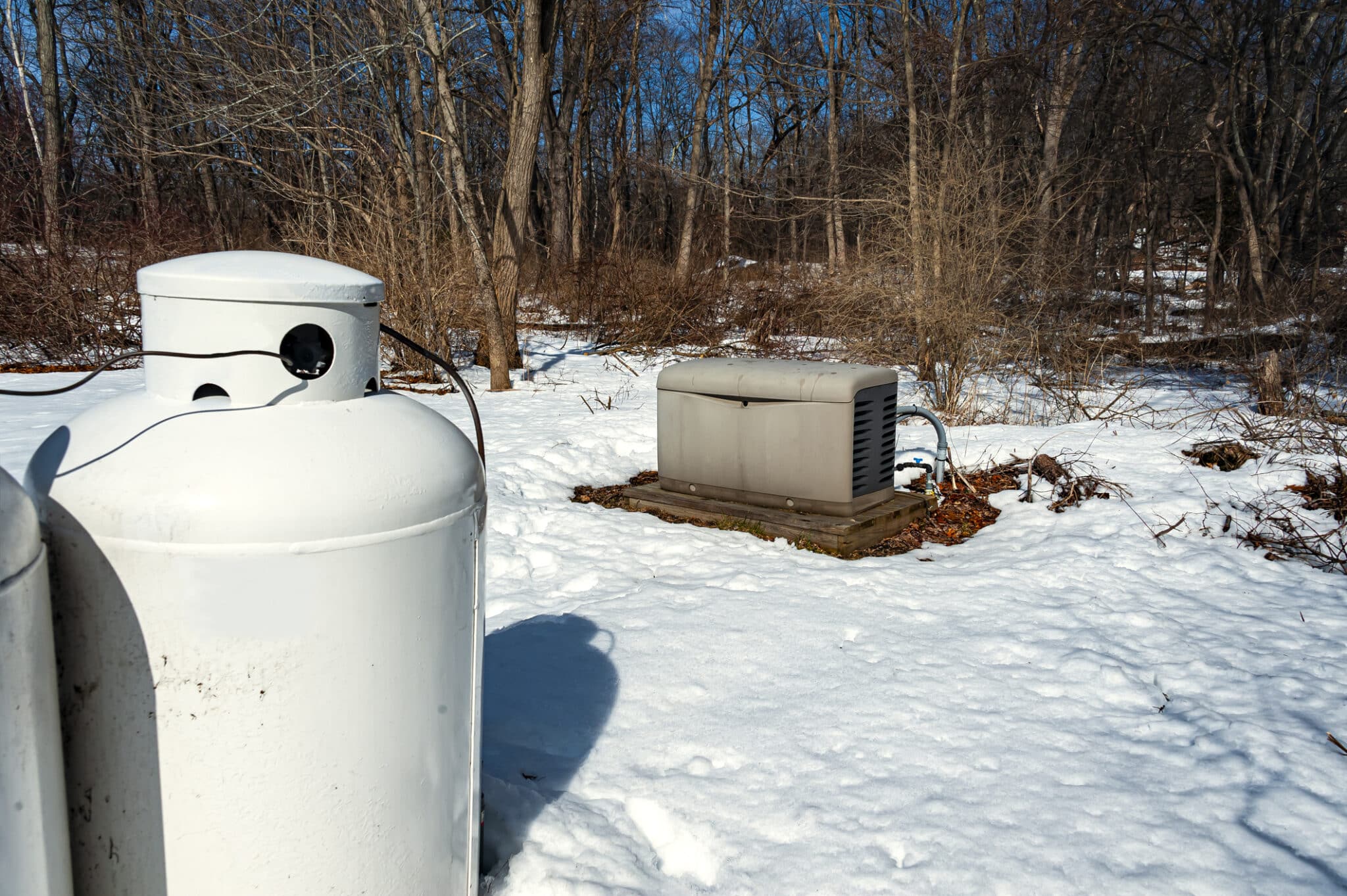 Residential standby generators installed on a concrete pad.