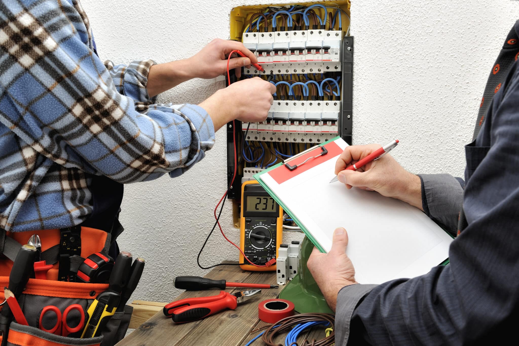 Electricians performing a home electrical inspection.