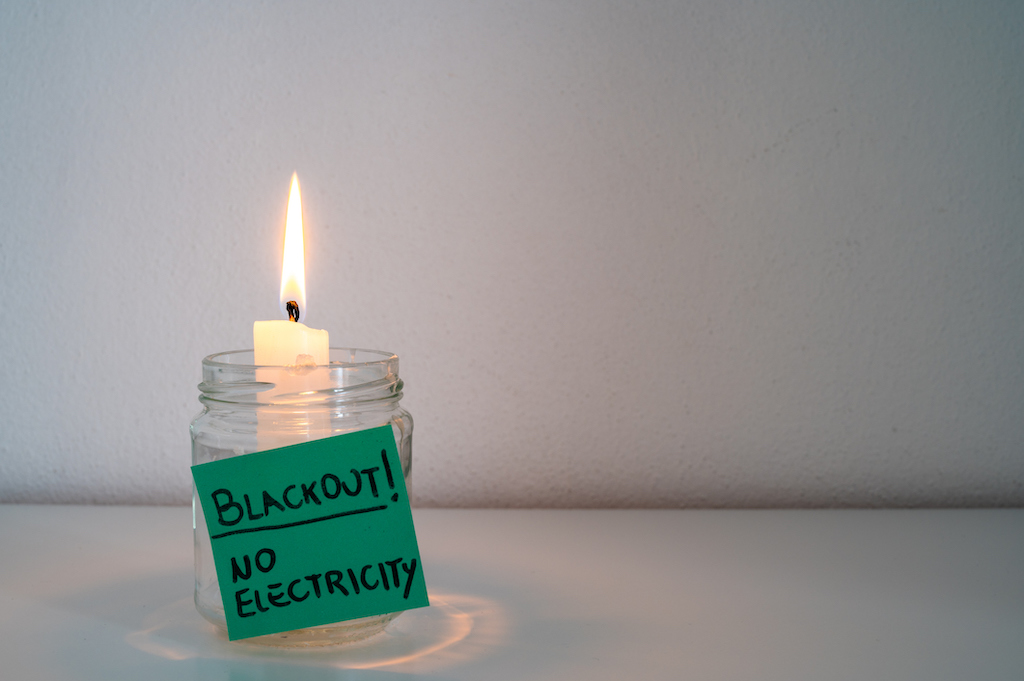 A candle with a sticky note that reads "Blackout! No electricity" Home in need of a generator services.