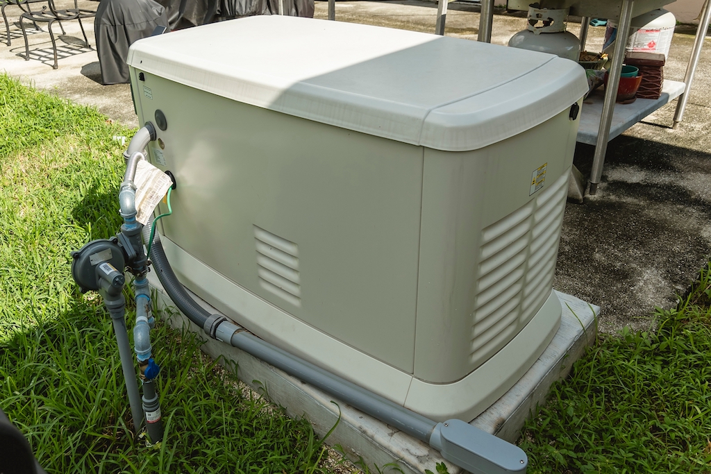 Home backup generator outside on grass. Generator services.