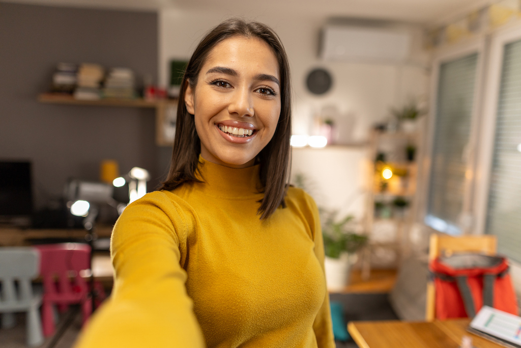 Woman in yellow shirt smiling at camera. | On-Site Generator Repairs